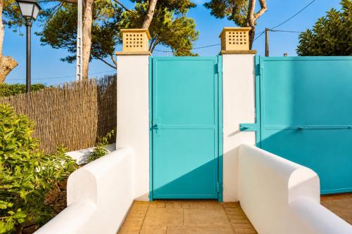 an open blue door on a white fence at Villa Riviera in Cala d´Or