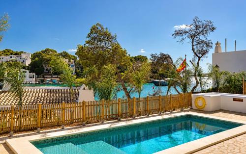 a swimming pool in front of a wooden fence at Villa Riviera in Cala d´Or