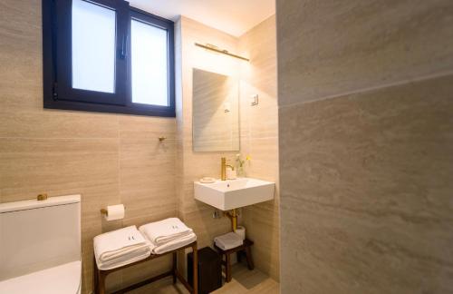 a bathroom with a sink and a toilet and a mirror at Hotel Maroussi in Athens