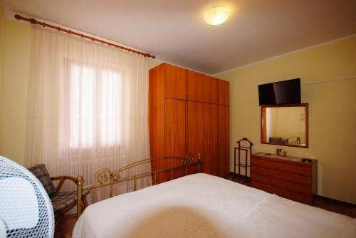 a bedroom with a bed with a dresser and a mirror at I due cipressi in Cagli