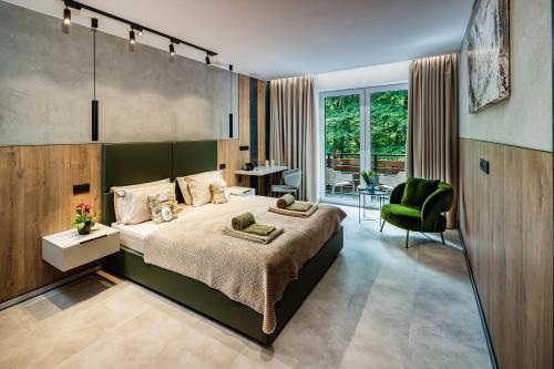 a bedroom with a large bed with a green headboard at DAS ERZ Medical Spa & Hotel in Crottendorf
