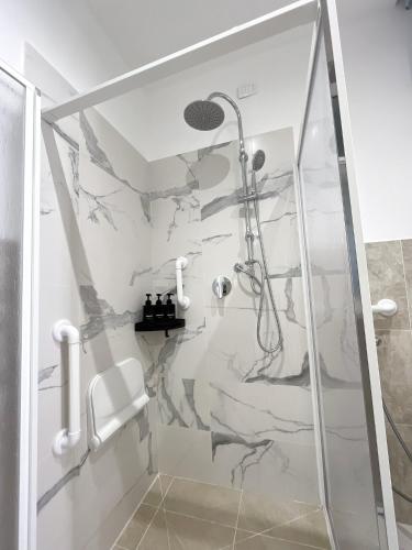 a bathroom with a shower with a marble wall at Palermo central stay in Palermo