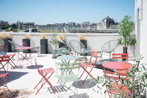 a patio with tables and chairs on a roof at Best Western Plus Hôtel de Robien in Saint-Brieuc