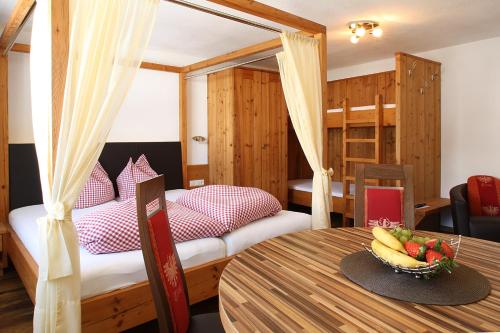 a room with a bed and a table with a bowl of fruit at Amontanara in Nauders
