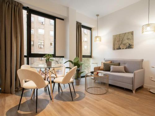 a living room with a couch and a table and chairs at Catalina Retiro Madrid in Madrid