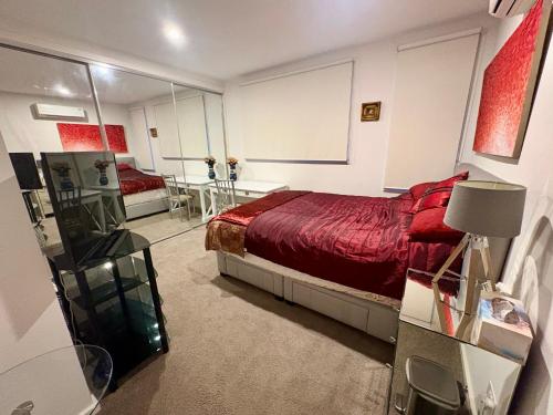 a bedroom with a bed with a red bedspread at Spacious Master Room with Private Ensuite in Melbourne