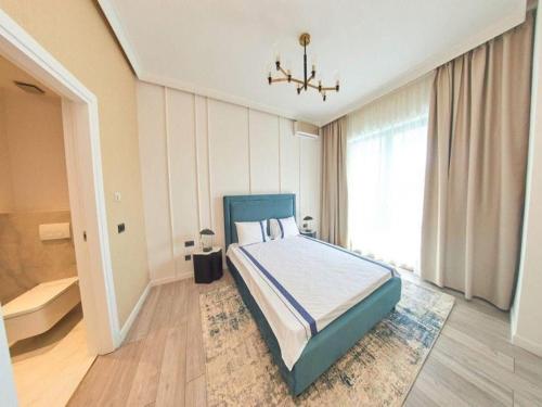 a bedroom with a bed with a blue headboard and a window at Apartament Marreo Casa del Mar in Mamaia