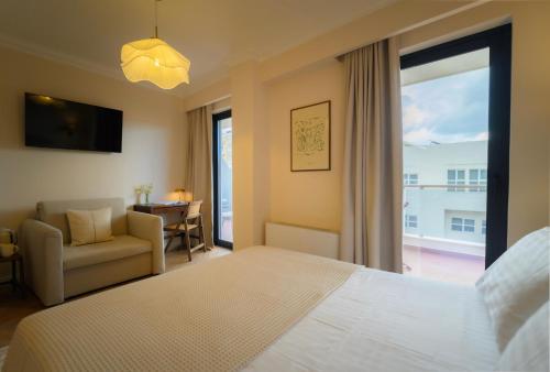 a bedroom with a bed and a couch and a window at Hotel Maroussi in Athens