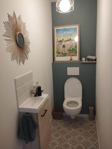 a bathroom with a toilet and a sink and a mirror at House in Clamart