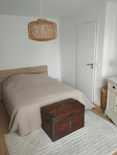 a bedroom with a bed with a wooden trunk on a rug at House in Clamart