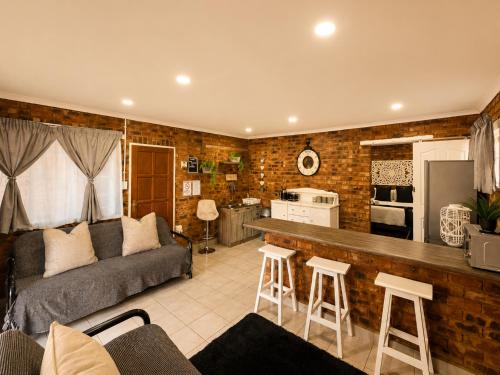 a living room with a couch and a kitchen at Zhantique Guest House 1- Unit 3 in Boksburg