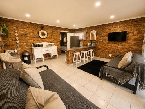 a living room with a couch and a kitchen at Zhantique Guest House 1- Unit 3 in Boksburg