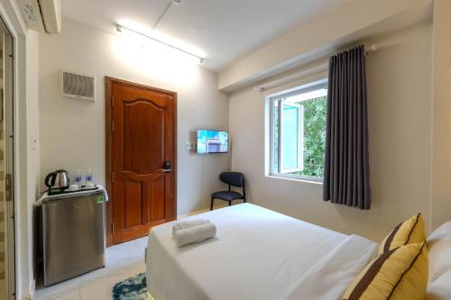 a bedroom with a bed and a window and a door at G8 Le Van Sy Hotel Saigon in Ho Chi Minh City