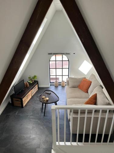 een woonkamer met een bank en een tafel bij Luxe Tiny House Ooij in Ooij