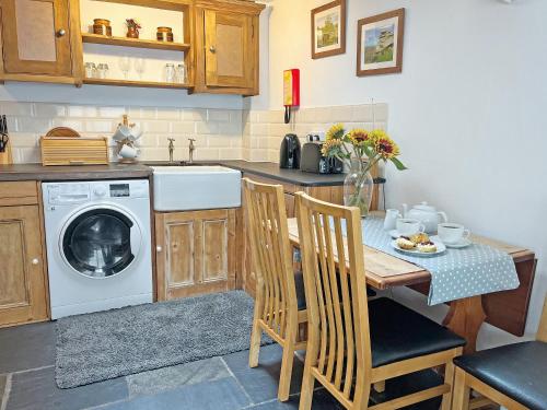 a kitchen with a table and a washing machine at Mole Cottage - Uk52139 in Liskeard