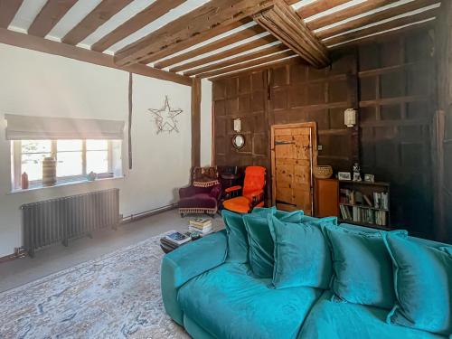 a living room with a blue couch in a room at The Cottage in Chelsworth