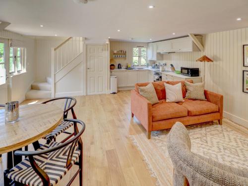 a living room with a couch and a table at Meadow Barn in Pulborough
