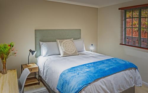 a bedroom with a large bed with a blue blanket at Gardenview Sedgefield in Sedgefield