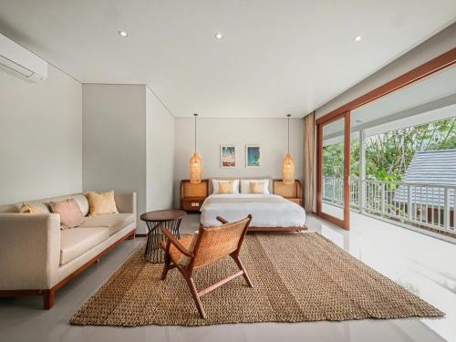 a bedroom with a bed and a couch at Agra & Amurti Villas in Munggu