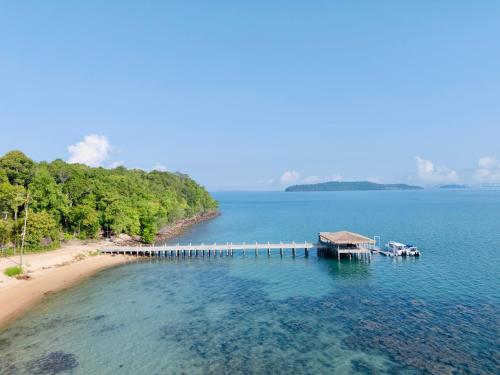 a dock in the water next to a beach at JATI Koh Russey in Sihanoukville