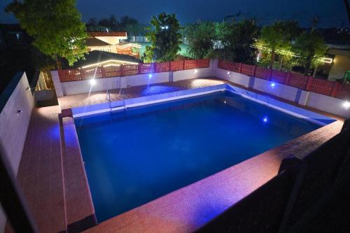 a swimming pool at night with blue lights at Sambhariya Bagh Resort in Kānota