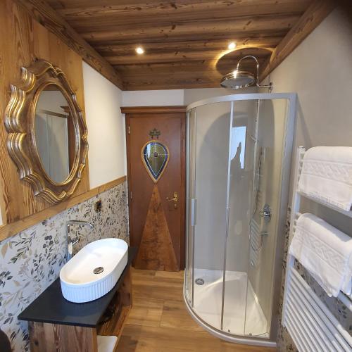 a bathroom with a shower and a sink and a mirror at Villa Martha Vintage Hotel-B&B in Santa Cristina Gherdëina