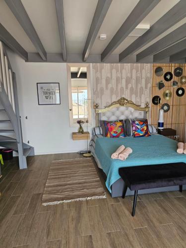 a bedroom with a bed and a staircase in it at les 2 dauphins in Le Barcarès