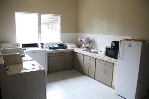a kitchen with a white refrigerator and a sink at DW Motel in Koror