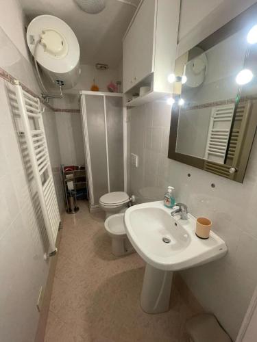a white bathroom with a sink and a toilet at A Casa di Zio Zeffy in Châtillon