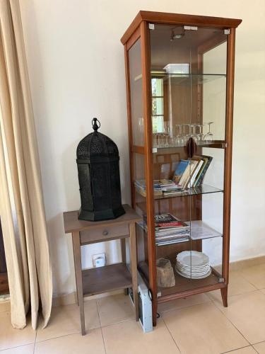 a cabinet with a mirror and a shelf with plates at Mas Ferrieres Saint Laurent in Saint-Laurent-le-Minier