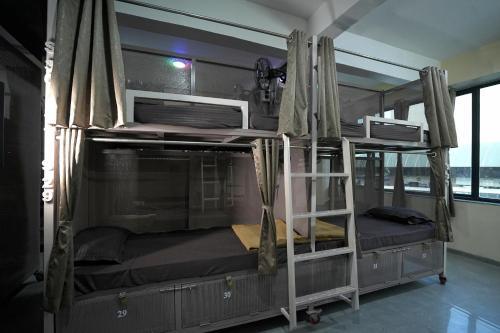 two bunk beds in a room with a window at Suvidha Dormitory Hotel in Bhuj