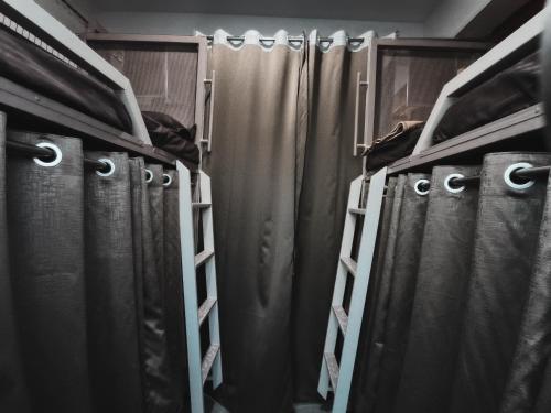 a row of curtains in a walk in closet at Suvidha Dormitory Hotel in Bhuj