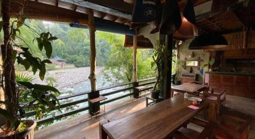 a room with a table and a view of a river at Sumatra Orangutan Tours Orangutan Trekking with Airport Pick Up Drop Off and Accommodation Trekking Required for All Bookings in Bukit Lawang