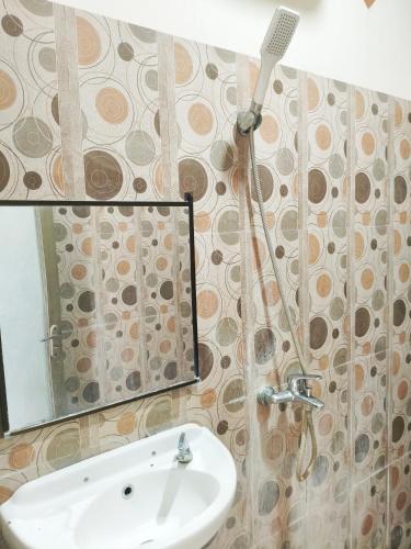 a bathroom with a sink and a shower at Nangas Homestayy in Huu