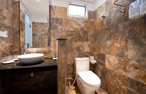 a bathroom with a toilet and a sink at Temple Beach Resort in Danang