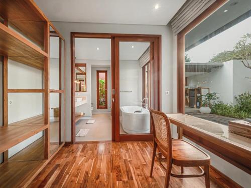 a bathroom with a tub and a large window at Agra & Amurti Villas in Munggu