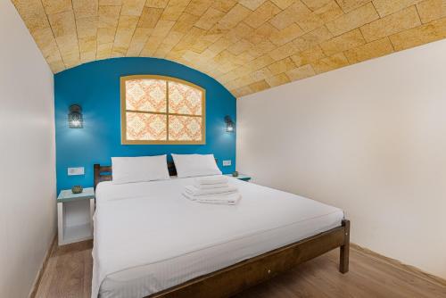 Opera Lane Suites في أوديسا: غرفة نوم بها سرير كبير وجدار أزرق
