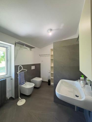 a bathroom with two sinks and a tub and a toilet at Clusone - Dosso Cascì in Clusone