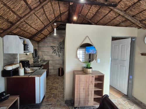 a kitchen with a counter and a mirror on the wall at Bosveld In Die Stad Lodge in Alberton