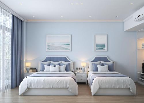 two beds in a bedroom with blue walls at TTC Lotus Hotel in Phú Quốc