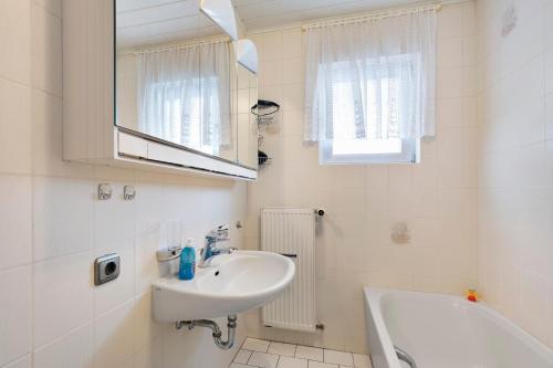 a bathroom with a sink and a mirror and a tub at Landidylle – Nostalgie in Ortenberg