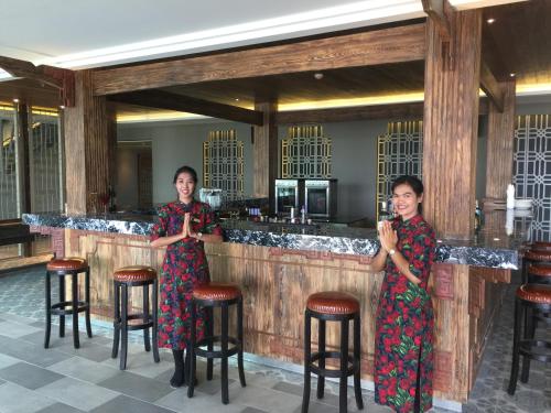 two women standing in front of a bar at Fusion Suites Phuket Patong in Patong Beach