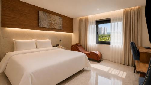 a bedroom with a large white bed and a window at Guwol Hotel in Incheon