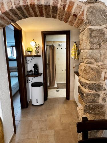 a room with a stone wall and a bathroom at Biba Holiday in Omišalj