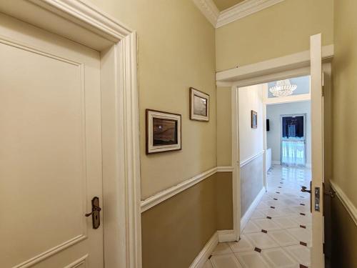 a hallway of a home with a door and a tile floor at Caradoc House in Muizenberg