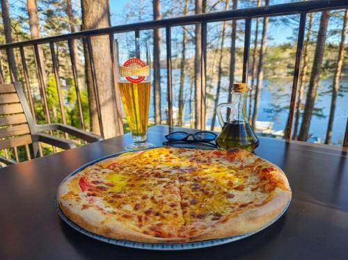 a pizza sitting on top of a table with a drink at Domek Ostróda in Ostróda