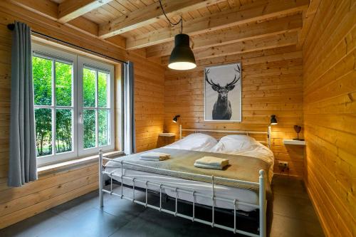 a bedroom with a bed in a wooden room at Luxe, rust en ruimte bij de Veluwse Vijf in Epe in Epe
