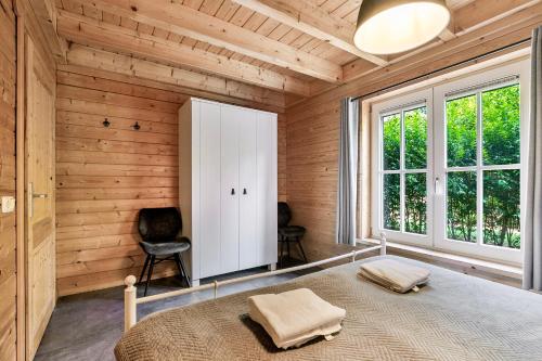 a bedroom with a bed in a room with wooden walls at Luxe, rust en ruimte bij de Veluwse Vijf in Epe in Epe
