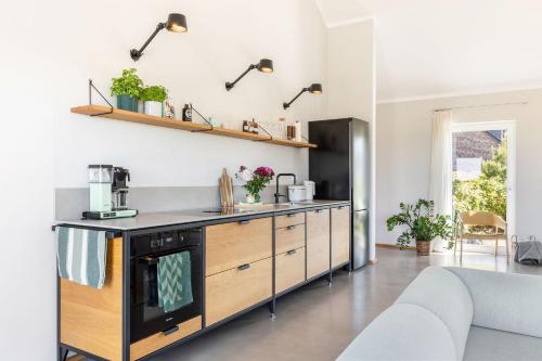 a kitchen with a counter and a stove at Feldkoje - Luxuriöses Design-Ferienhaus mit Kamin und Feldrandlage in Fehmarn