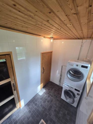 a laundry room with a washing machine and a washer at Revontulet ZH Tulimetsän Kylä in Pieksämäki